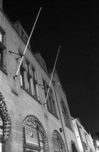 883864 Gezicht op de voorgevel van de studentensociëteit P.H.R.M. (Janskerkhof 14) te Utrecht, bij nacht.